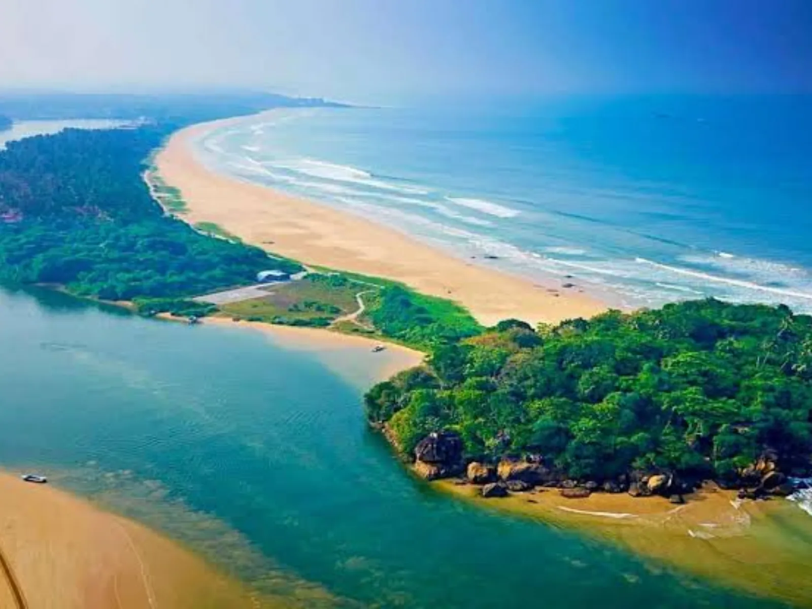 Aerial view of the Bentota River meeting the Indian Ocean along a forested spit of land