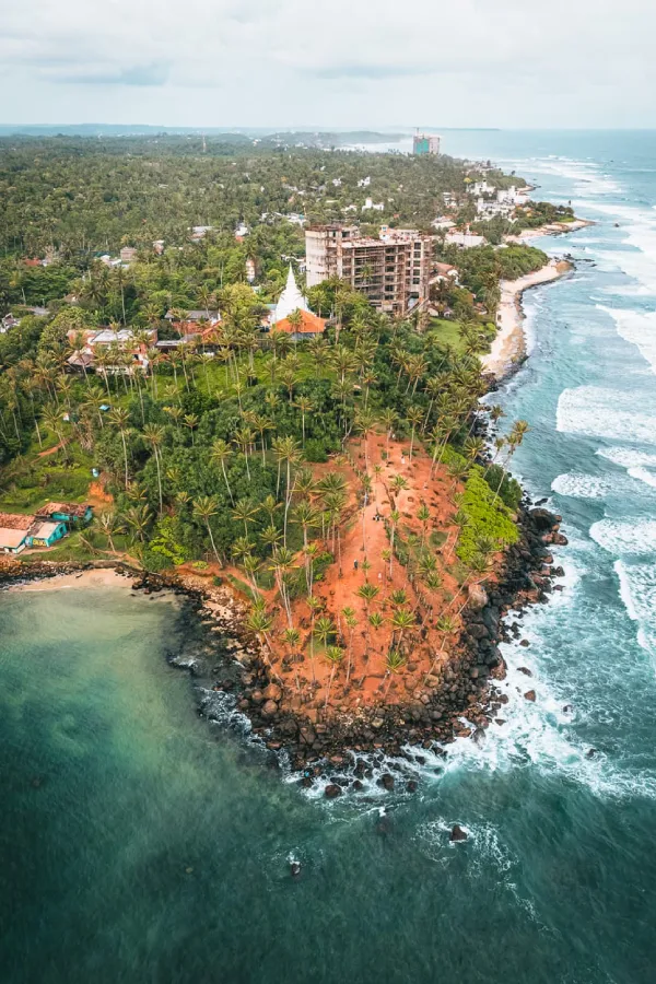 Aerial view of a palm-covered coastal headland along the Mirissa shoreline